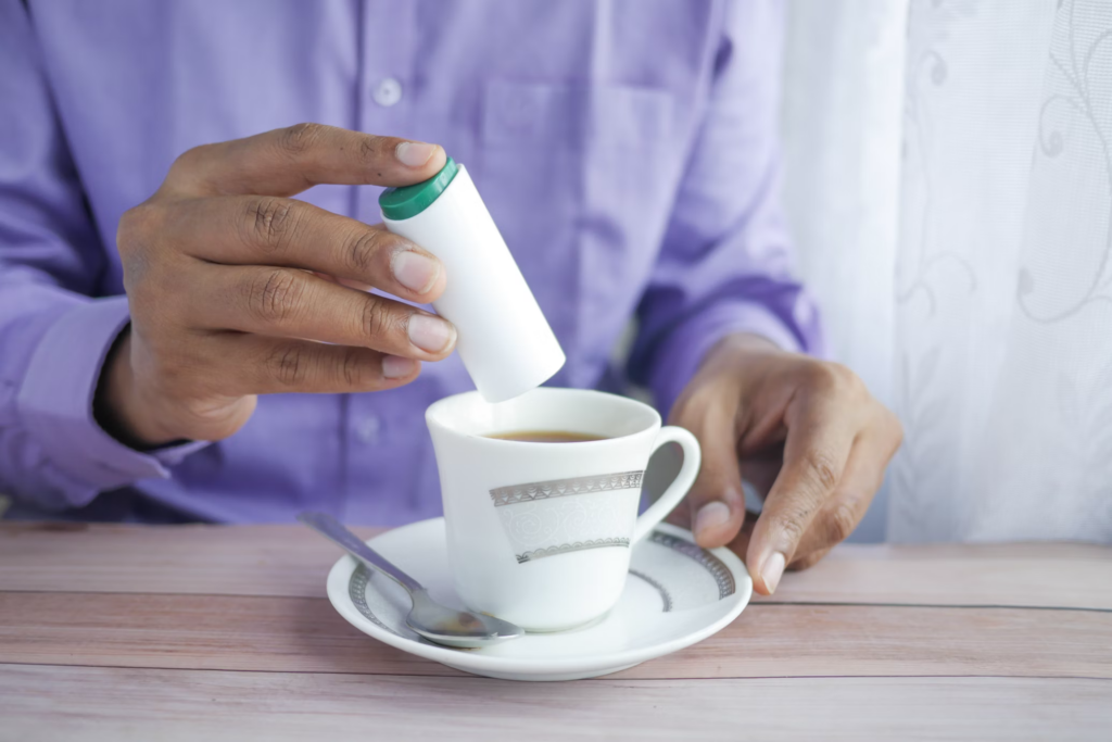 A man pours coffee into a cup, drawing attention to the ongoing discussion in recent research about artificial sweeteners and their potential health effects for people over 60.