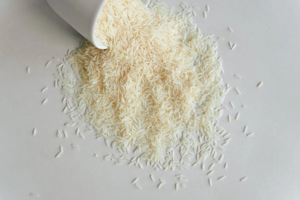 Rice being poured into a white bowl, illustrating the impact of refined grains on blood sugar levels in older adults.