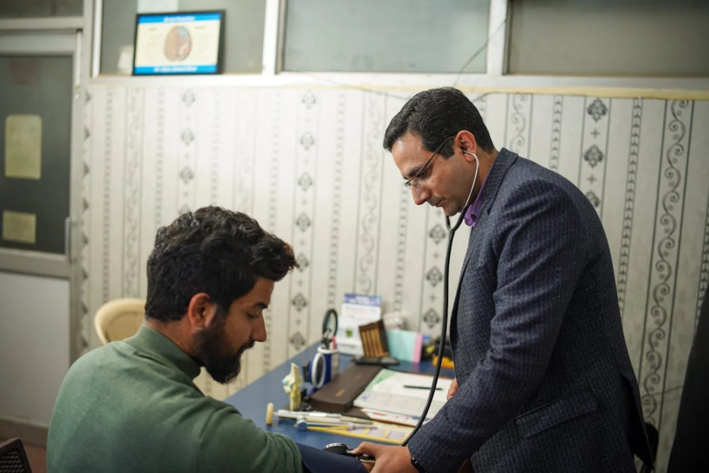 A man receives a blood pressure check from a caring healthcare professional in a clinical setting.