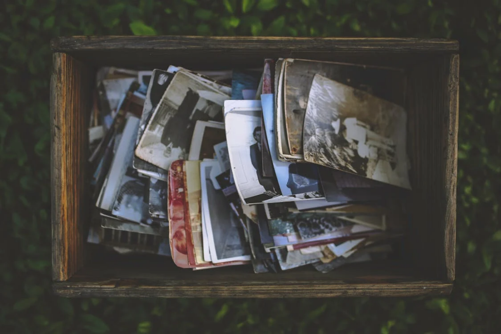 A wooden box overflowing with old photos, symbolizing memories fading due to early dementia's impact on forgetfulness.