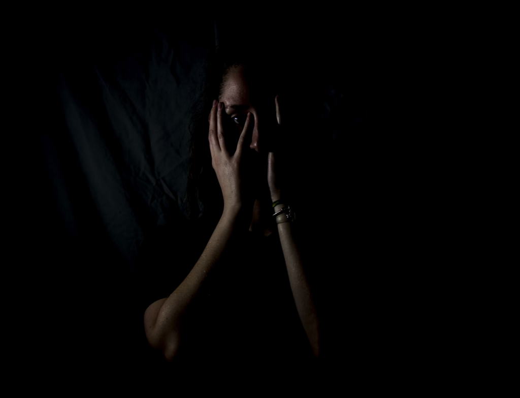 A person covers their face with their hands, reflecting feelings of worry or distress, possibly linked to early dementia signs.