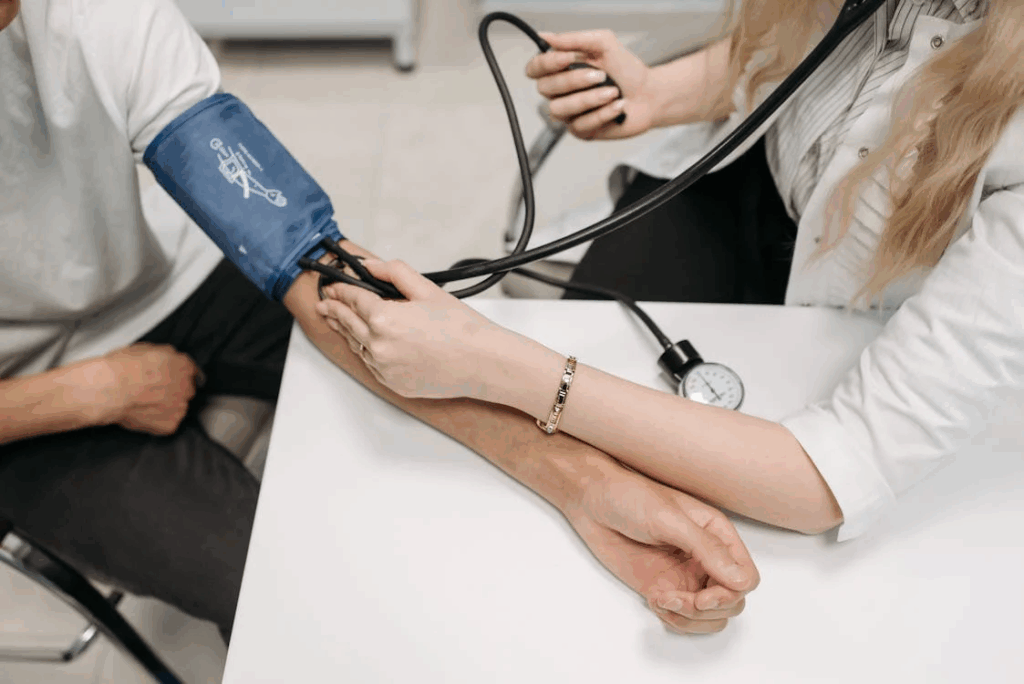 Healthcare provider taking patient's blood pressure during preventive cardiac screening.