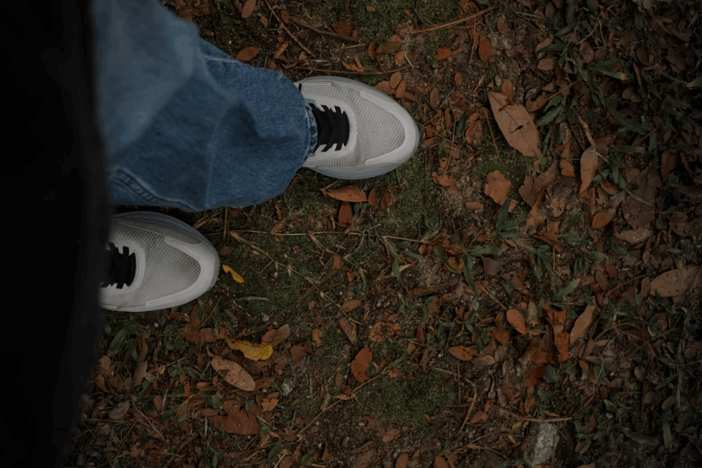 Person's feet on autumn ground during daily walk.